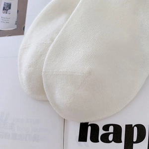 Close-up of white cotton knit sock toe with seamless stitching and fine texture