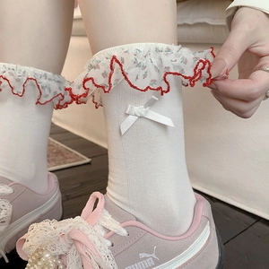 Detail of floral lace trim and white satin bow on cream mid-calf lolita style socks