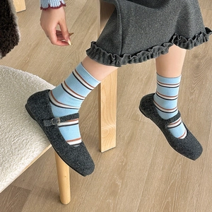 Detailed view of retro orange-brown striped mid-calf socks with wool Mary Jane flat shoes