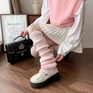 Detail of pink knitted leg warmers with ribbed texture in a preppy school style