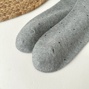 Detail shot of grey knitted socks with black polka dots and flat seamless toe finish