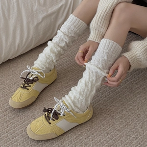 Detail of cable knit pattern and cozy texture on white slouchy leg warmers