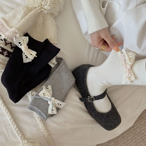 Vue détaillée de chaussettes vintage à côtes avec dentelle ajourée et nœuds élégants