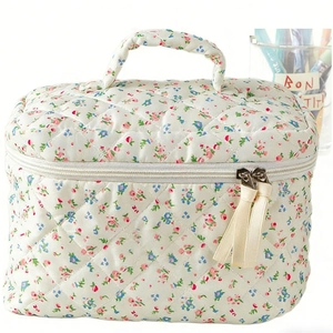 Quilted floral makeup bag in cream with red and blue flowers and handle