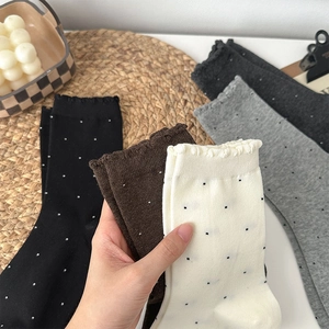 Detail of ruffled cuffs on polka dot crew socks featuring soft knitted cotton texture