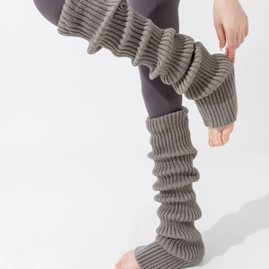 Close-up of grey ribbed knit leg warmers showing thick texture and stirrup foot design