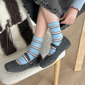 Retro grey Mary Jane shoes with light blue striped mid-calf socks for an academic look