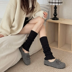 Women's black cable knit leg warmers with wood ear edges in a cozy winter style