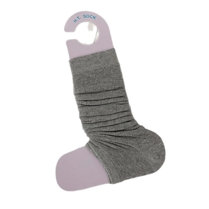 Grey knitted slouch leg warmers with vertical ribs on a minimalist display hanger