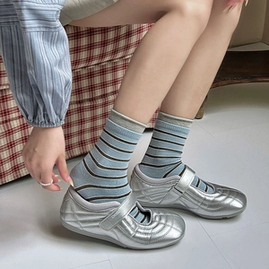 Detailansicht gestreifter Socken kombiniert mit silbernen Mary-Jane-Schuhen mit Klett