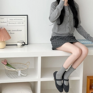 Chic lifestyle scene with grey knit cardigan and dark polka dot crew socks