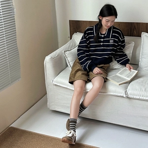 Nahaufnahme gestreifter Crew-Socken kombiniert mit braunen Cordshorts und Wildledersneakern