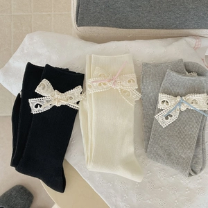 Détail de chaussettes en maille côtelée avec nœuds en dentelle élégants en blanc et gris