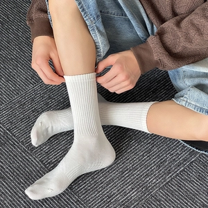 Detail of white ribbed cotton crew socks showing breathable texture and elastic cuff
