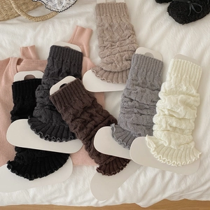 Close-up of cable knit leg warmers in five colors with vintage ruffled edges