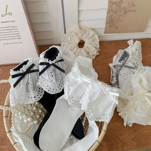Detailed close-up of Lolita lace trim socks with silk bows and exquisite embroidery