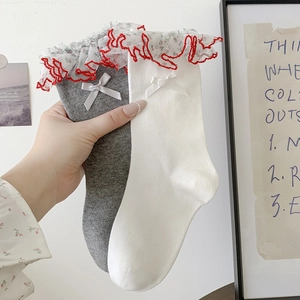 Detail of grey and white socks featuring double-layer lace trim and red wavy edges