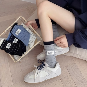 Close-up of striped cotton socks with a cute bear tag and knit texture detail