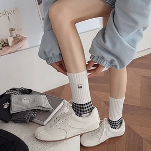 Close-up of retro plaid cotton socks with cat embroidery and ribbed knit texture