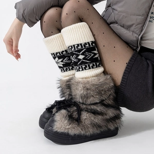 Détail des jambières à motif Fair Isle portées avec des bottes de neige en fourrure