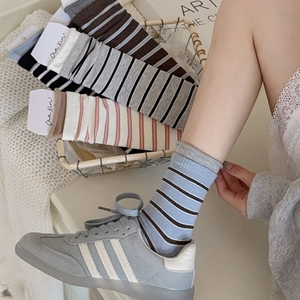 Detail of vintage blue-grey striped crew socks in a rustic wicker basket