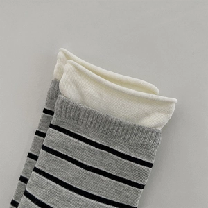 Detail von Strickstrümpfen mit grauschwarzen Streifen und weißem Rollsaum für Damen
