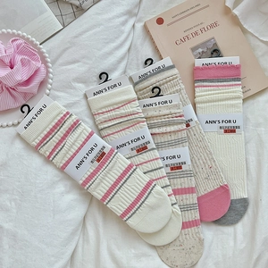 Dettaglio di calze termiche a righe con fiocchi carini e motivi a cuore rosa
