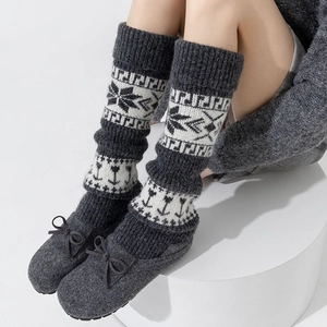 Détail de jambières en maille Fair Isle à motifs flocons et de chaussons en feutre gris