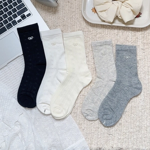 Detail of knit socks with delicate bow embroidery and lace mesh pattern