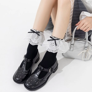 Detail of black JK socks with white lace trim and black satin bow in ballet style