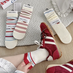 Detail of vintage striped knit cotton socks with red hearts and stylish lace cuffs