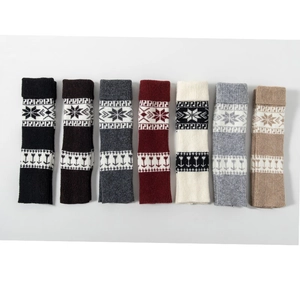 Vue à plat de jambières en tricot Fair Isle en sept couleurs avec motifs de flocons de neige