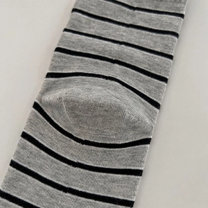 Makroaufnahme von gestreiften Socken mit grau-schwarzer Rippstruktur und feiner Verarbeitung