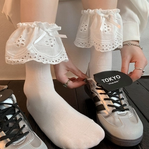 White ballet style knee-high socks with delicate lace trim and ribbon bow accents