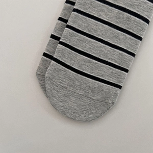 Nahaufnahme der nahtlosen Zehenpartie bei gestreiften hellgrauen Crew-Socken aus Baumwolle
