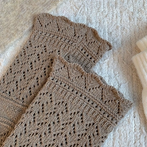 Close-up of coffee brown crochet leg warmers with vintage hollow out knit patterns