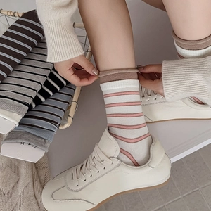 Detail of retro striped mid-calf socks with stylish rolled cuffs in vintage blue and grey