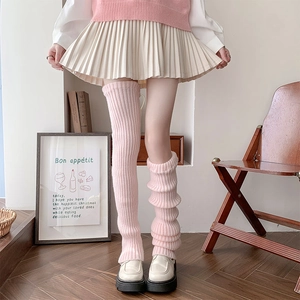 Detailed knit texture of pink leg warmers showing over-knee and slouched styling