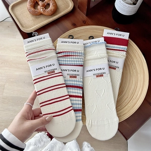Macro detail of cotton college-style striped socks with heart lace and paper packaging