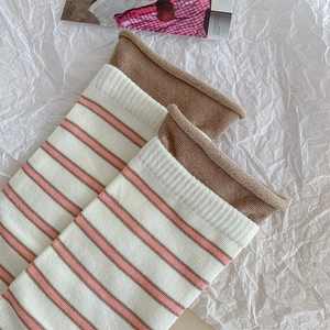 Detail of striped cotton socks with rolled edges and soft pink and beige stripes