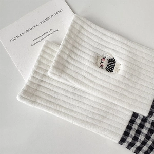 Detailed view of white cotton socks with cat embroidery and black and white check pattern