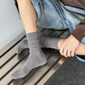 Detail view of grey ribbed cotton blend crew socks with premium knit texture on feet