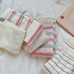 Dettaglio calzini in maglia a righe rosa e grigie con motivo a pois strutturato