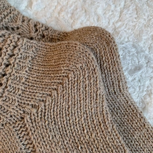 Detail of cream white knit calf socks with textured ribbed pattern and hollow lace edge