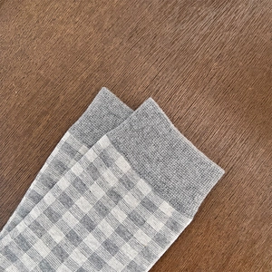 Close-up of elastic ribbed cuff on vintage grey and white checkered cotton socks