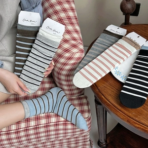 Nahaufnahme von mehrfarbig gestreiften Baumwollsocken mit Rippbündchen in gemütlichem Stil