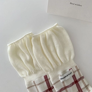 Detail of vintage plaid mid-calf socks with cream knit ruffles and brand label