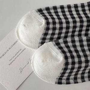 Detail of vintage black and white checkered socks with fine knit texture and white toe