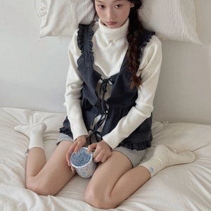Detail of white ribbed crew socks paired with a sweet home outfit on a cozy bed scene