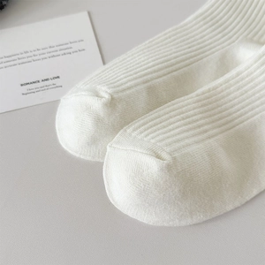 Detail of white rib-knit ballet style socks showing high-quality toe seam and texture